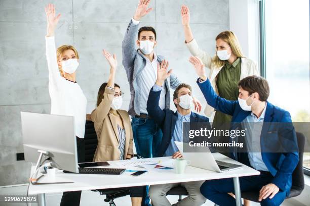 group of business people celebrating their success with hands clasped together - employee engagement mask stock pictures, royalty-free photos & images