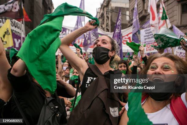 Pro-choice demonstrators hold up green kerchiefs and shout slogans as Deputies give half sanction to a bill to legalize abortion on December 11, 2020...