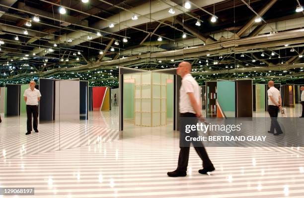 Visitor explores one of the 70 "exploded cabins" in French artist Daniel Buren's installation at the Georges Pompidou Center 26 June 2002. "Le musee...