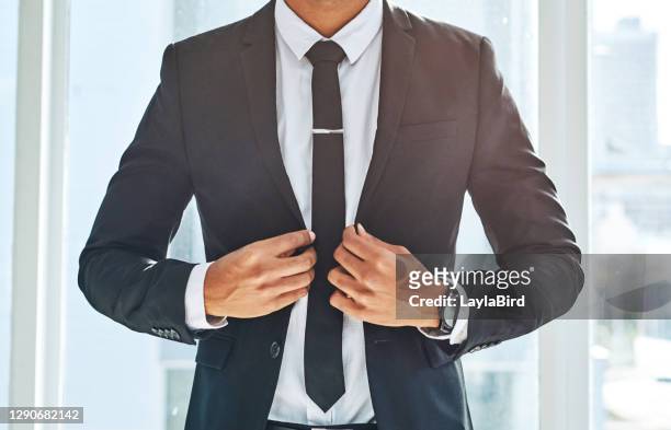 succes past perfect bij een stijlvol pak - adjusting necktie stockfoto's en -beelden