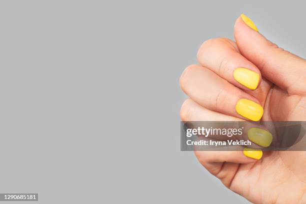 stylish trendy yellow manicure on abstract bright illuminating yellow and gray colours background. - painting fingernails stock pictures, royalty-free photos & images