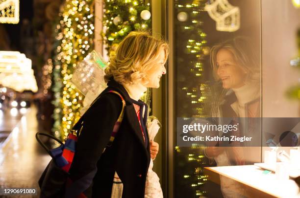 beautiful mature woman window shopping in christmassy decorated street - christmas in rome stock pictures, royalty-free photos & images