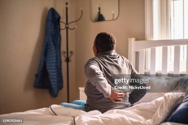 suffering from back pain in morning - lower back stock pictures, royalty-free photos & images