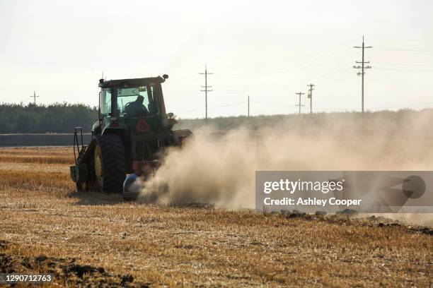 a farmer ploughs a field in wasco in the central valley of california that has turned to dust following the four year long drought in the western usa. - bakersfield stock pictures, royalty-free photos & images