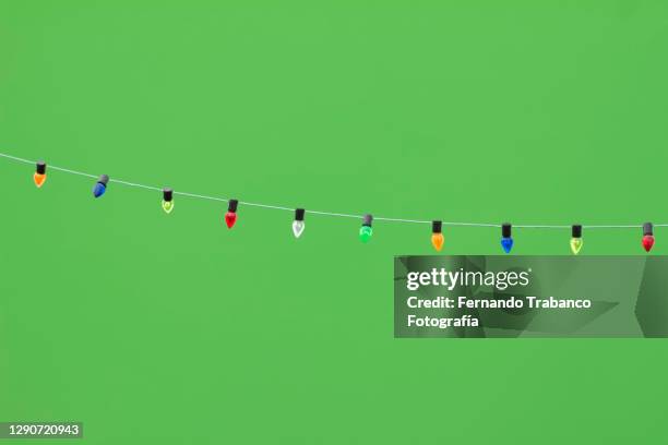 colored light bulbs on green background - luzes de natal imagens e fotografias de stock