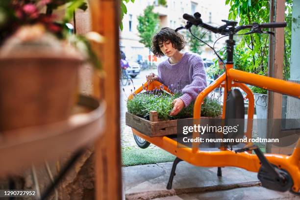 flower shop owner loading a cargo bike - ebike stock-fotos und bilder