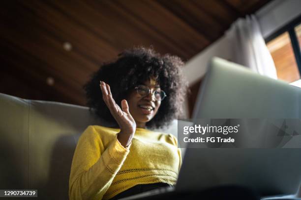 adolescente ragazza una videochiamata su laptop a casa - teen webcam foto e immagini stock