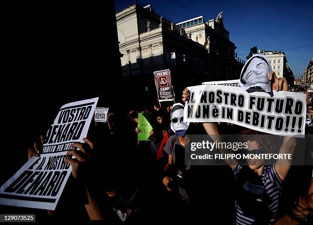 An indignant holds a banner reading in Italian "Our future is not a debt" as he takes part in a protest against the Bank of Italy in the centre of...