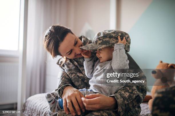 長い時間の後に彼女の赤ちゃんの息子に会う若い女性の兵士 - 軍隊 ストックフォトと画像