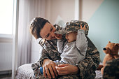 Young woman soldier meeting her baby son after a long time