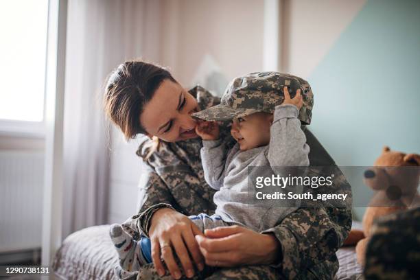 young woman soldier meeting her baby son after a long time - tropa imagens e fotografias de stock
