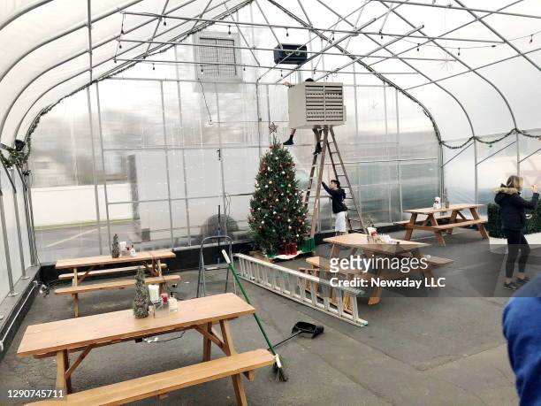 Restoration Kitchen & Cocktails in Lindenhurst, New York has built an adjacent greenhouse with picnic tables to accommodate customers for wintertime...