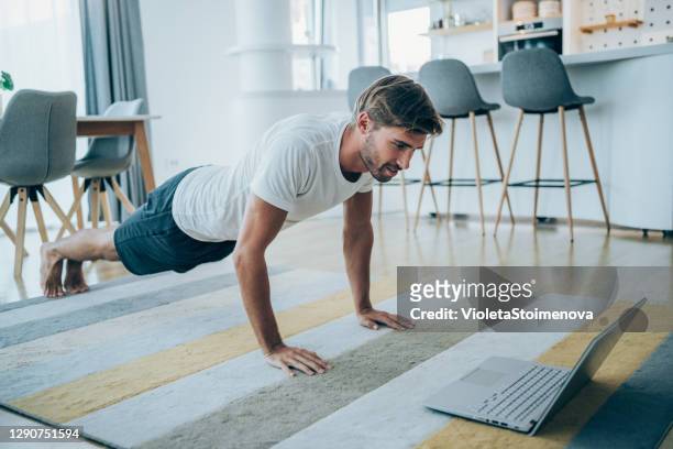 young man exercising at home. - push ups stock pictures, royalty-free photos & images