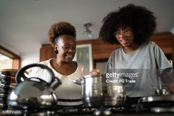daughter and mother cooking together at home - teenager cooking stock pictures, royalty-free photos & images