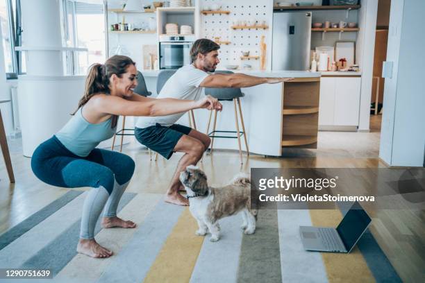 couple exercising together at home. - sports training stock pictures, royalty-free photos & images
