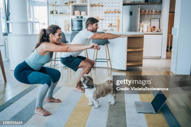 couple exercising together at home. - agachar se imagens e fotografias de stock