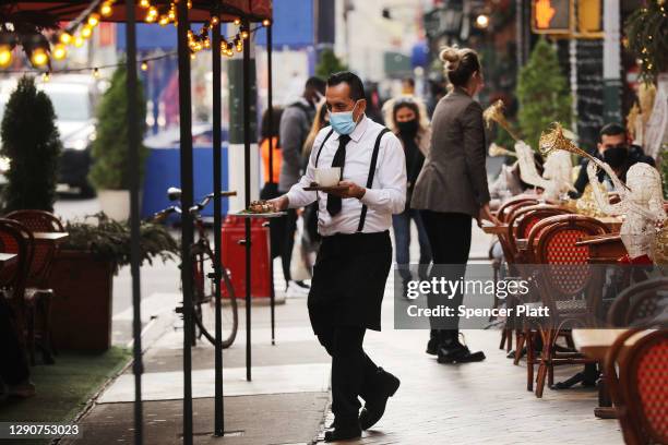 Waiter moves between tables outside of a restaurant in Manhattan on December 11, 2020 in New York City. New York’s governor, Andrew Cuomo, has...