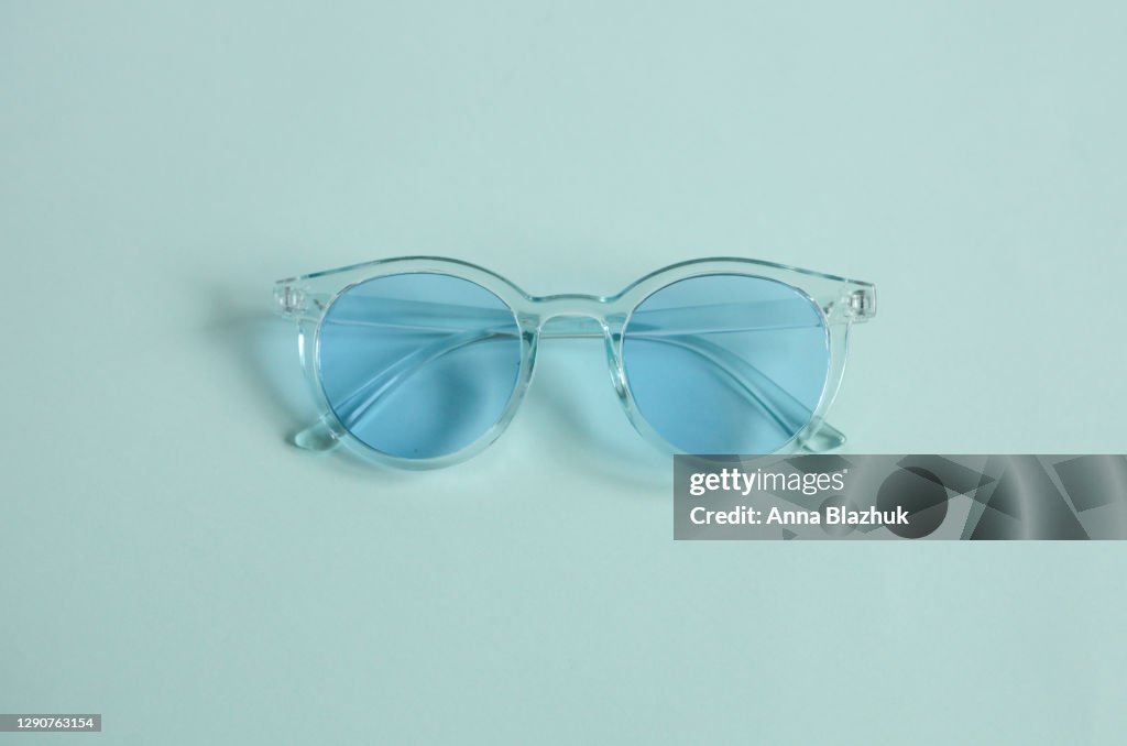 Monochrome trendy blue picture of sunglasses over blue background
