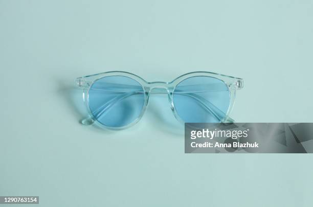 monochrome trendy blue picture of sunglasses over blue background - still life foto e immagini stock