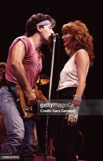 American Rock musicians Bruce Springsteen, on guitar, and backing vocalist Patti Scialfa of the E Street Band, perform onstage during the 'Born in...