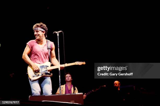 American Rock musician Bruce Springsteen plays guitar as he performs onstage, with the E Street Band, during the 'Born in the USA' tour, at Giants...