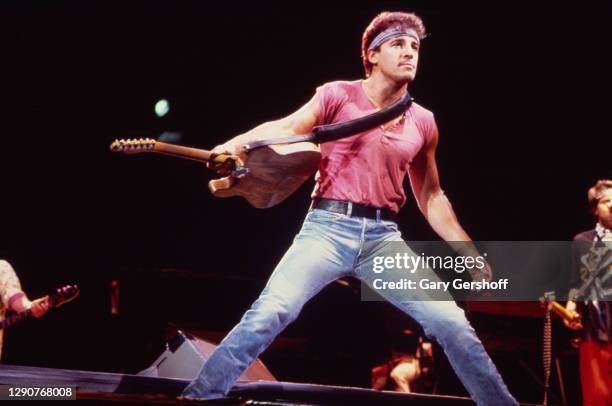 American Rock musician Bruce Springsteen plays guitar as he performs onstage, with the E Street Band, during the 'Born in the USA' tour, at Giants...