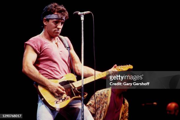 American Rock musician Bruce Springsteen plays guitar as he performs onstage, with the E Street Band, during the 'Born in the USA' tour, at Giants...