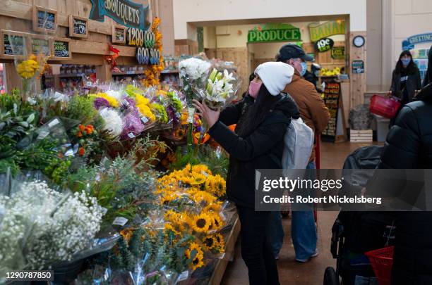 Woman selects fresh flowers to buy November 23, 2020 in a Trader Joe's supermarket in New York City.