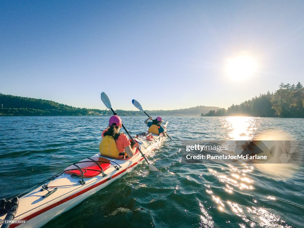 Mother and Daughter Kayaking Together, Suburban Neighborhood in Background