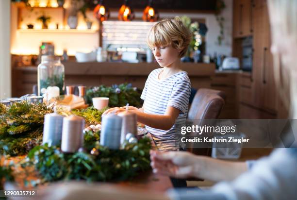 family making an advent wreath, focus on little boy - advent wreath stock pictures, royalty-free photos & images