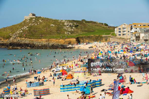holiday makers on the beach in st ives, cornwall, uk. - beach shelter stockfoto's en -beelden