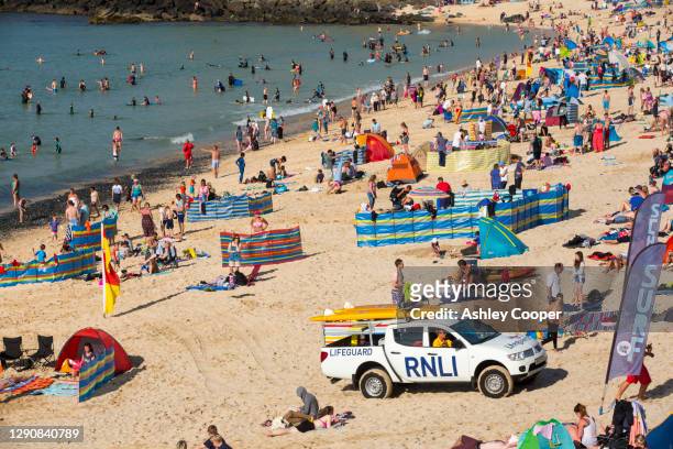 holiday makers on the beach in st ives, cornwall, uk. - windbreak stock-fotos und bilder