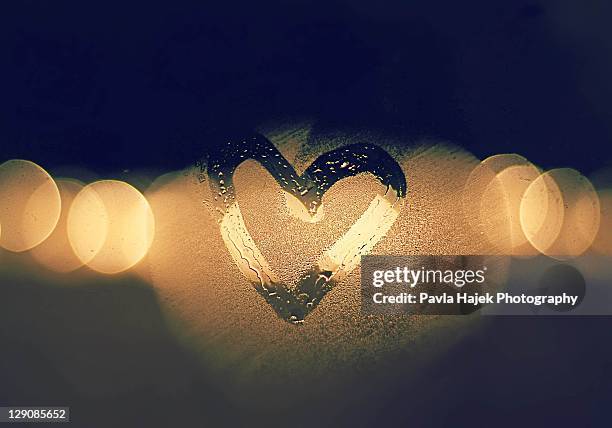 heart drawn with warm breath on cold window - mirror steam fotografías e imágenes de stock