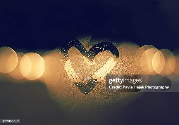 heart drawn with warm breath on cold window - mirror steam stockfoto's en -beelden