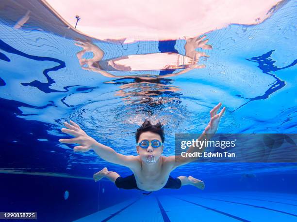 unter wasser ansicht asiatische chinesische teenager schwimmen im schwimmbad - underwater film camera stock-fotos und bilder