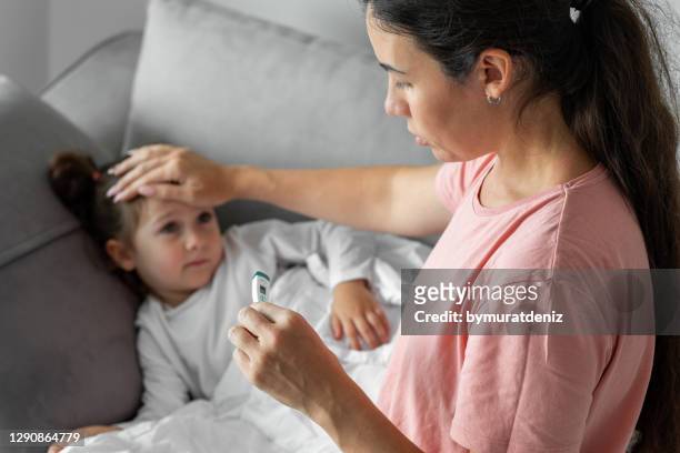 mother using thermometer - altitude sickness stock pictures, royalty-free photos & images