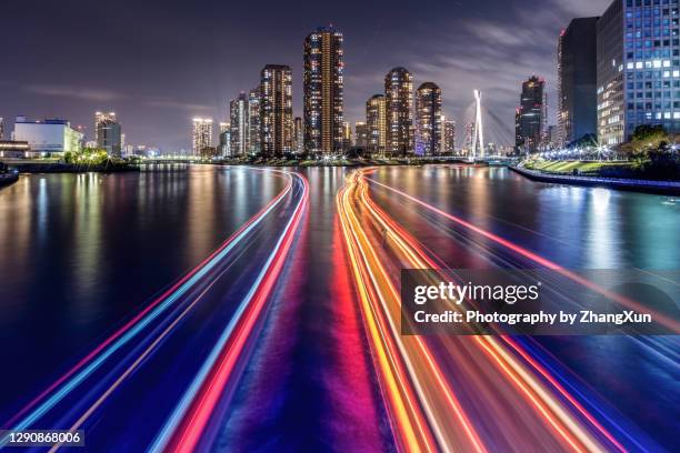 tokyo skyline in tsukishima waterfront area, koto ward, japan at night. - rastros de luz fotografías e imágenes de stock