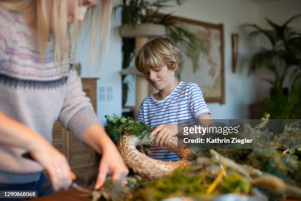 family making an advent wreath, focus on little boy - christmas craft stock pictures, royalty-free photos & images