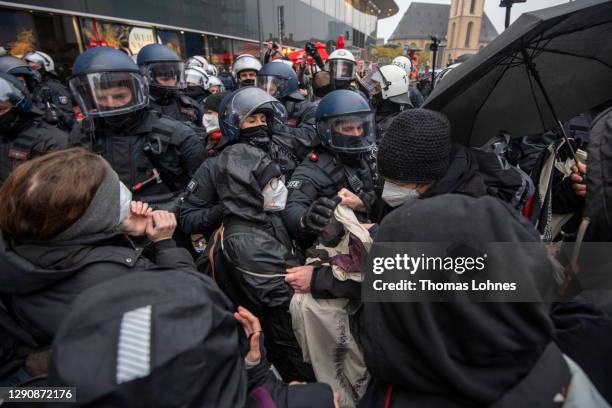 Police officers push left-wing Antifa counter demonstrators back while the demonstrat against opponents of what they claim are restrictions to their...