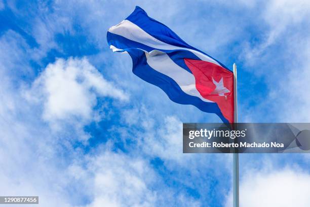 cuban flag flying in blue sky - cuban flag ストックフォトと画像