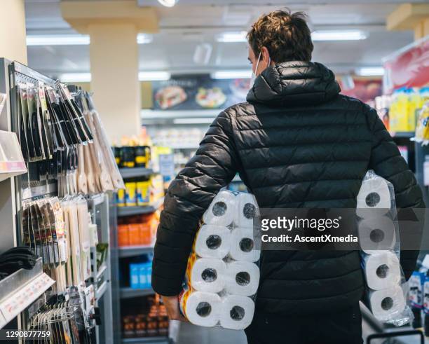 young man wearing protective face mask shops in grocery store - toilet paper stock pictures, royalty-free photos & images