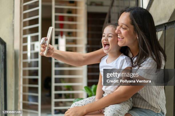 mother and daughter talking by video call - tia imagens e fotografias de stock