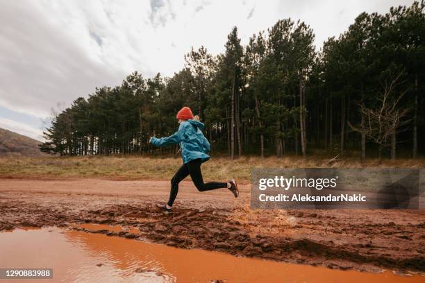 young woman exercising on extreme terrain - mud runner stock pictures, royalty-free photos & images