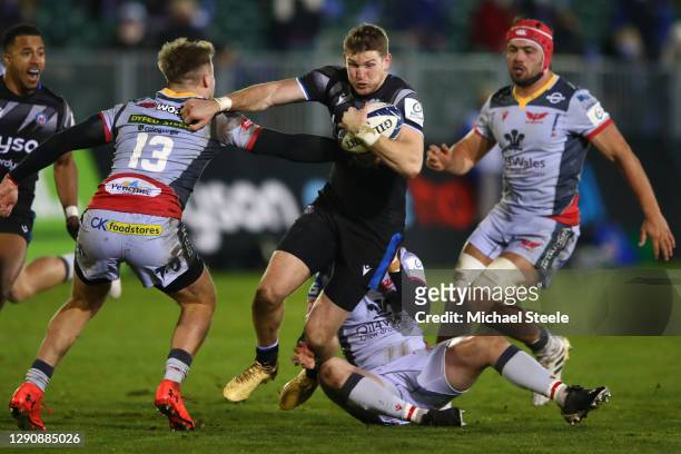 Ruaridh McConnochie of Bath holds off Tyler Morgan as Angus O'Brien of Scarlets holds on in the tackle during the Heineken Champions Cup Pool 1 match...
