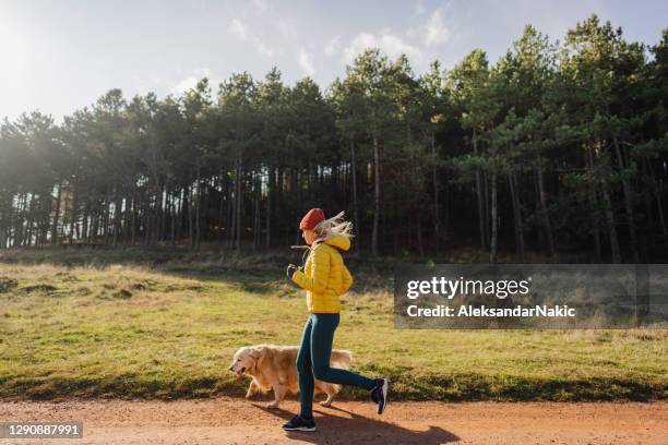 jeune femme faisant du jogging avec son crabot - jogging winter photos et images de collection