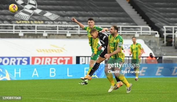 Dwight Gayle of Newcastle United heads to score their team's second goal under pressure from Dara O'Shea and Branislav Ivanovic of West Bromwich...