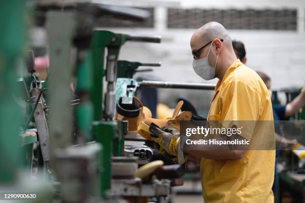 lateinamerikaner arbeitet während der covid-19-pandemie in einer schuhfabrik und trägt eine gesichtsmaske - leather shoe stock-fotos und bilder