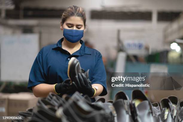 woman working at a shoe factory wearing a facemask - leather industry stock pictures, royalty-free photos & images
