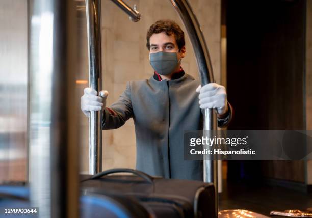 bellhop working at a hotel wearing a facemask - porter stock pictures, royalty-free photos & images
