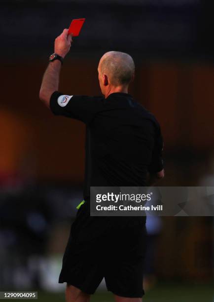 Referee Mike Dean shows a red card to Douglas Luiz of Aston Villa during the Premier League match between Wolverhampton Wanderers and Aston Villa at...